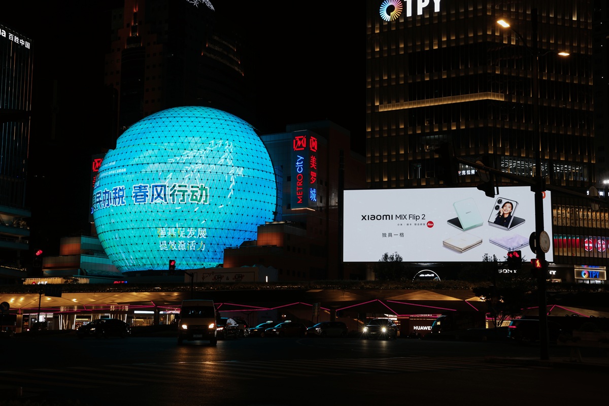 Teal LED globe billboard at night in Shanghai