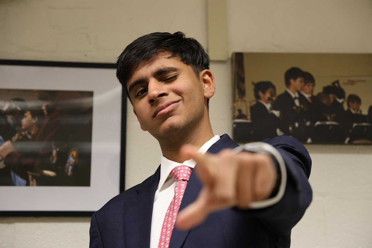 Jazz band student in navy suit pointing at camera