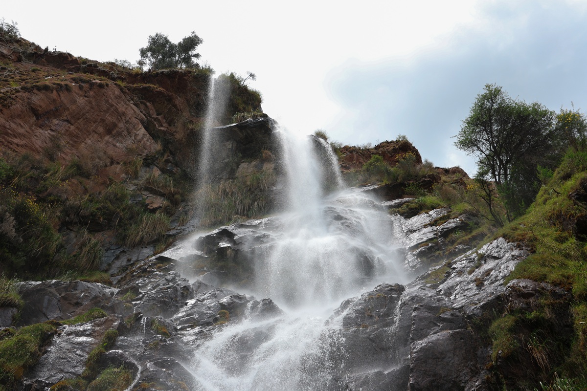 Twin waterfalls cascading down red rock cliffs
