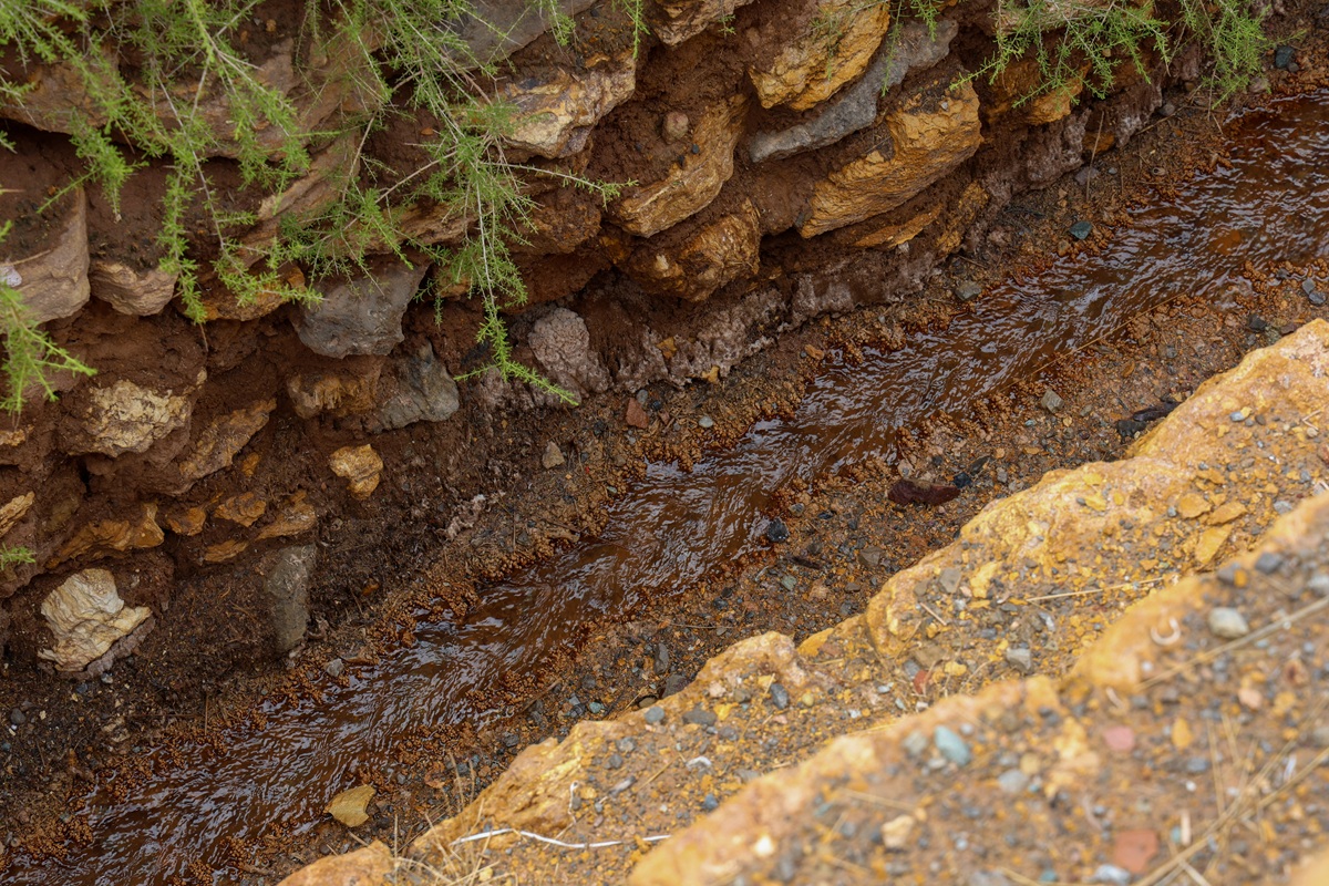 Rust-colored mineral stream through ochre rock