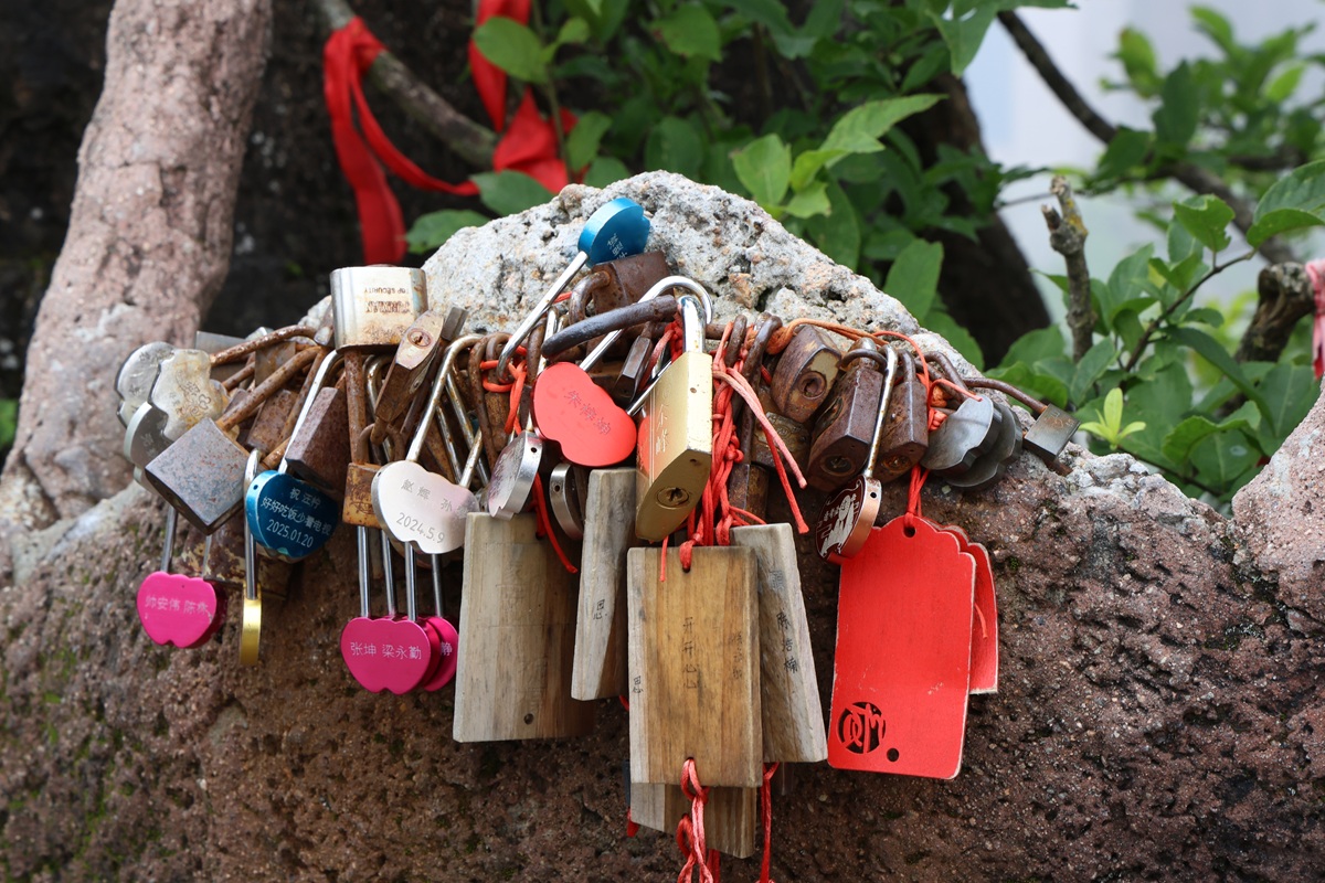 Love locks on a granite rock with red ribbons
