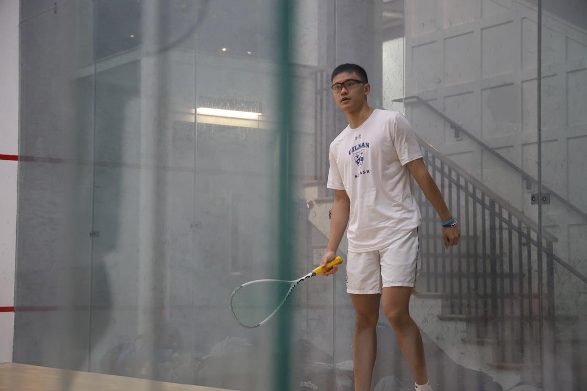 Gilman squash team huddle with coach before match