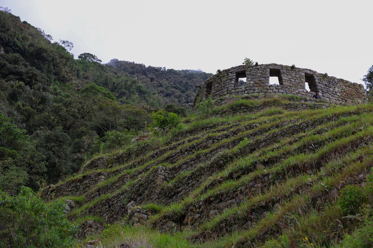 Inca terraces with circular stone ruin on the hillside