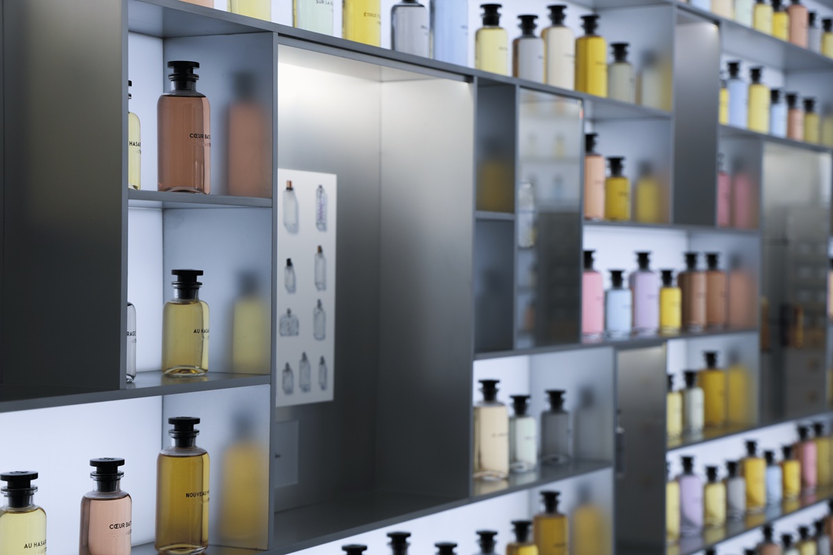 Louis Vuitton perfume bottles arranged on illuminated shelves