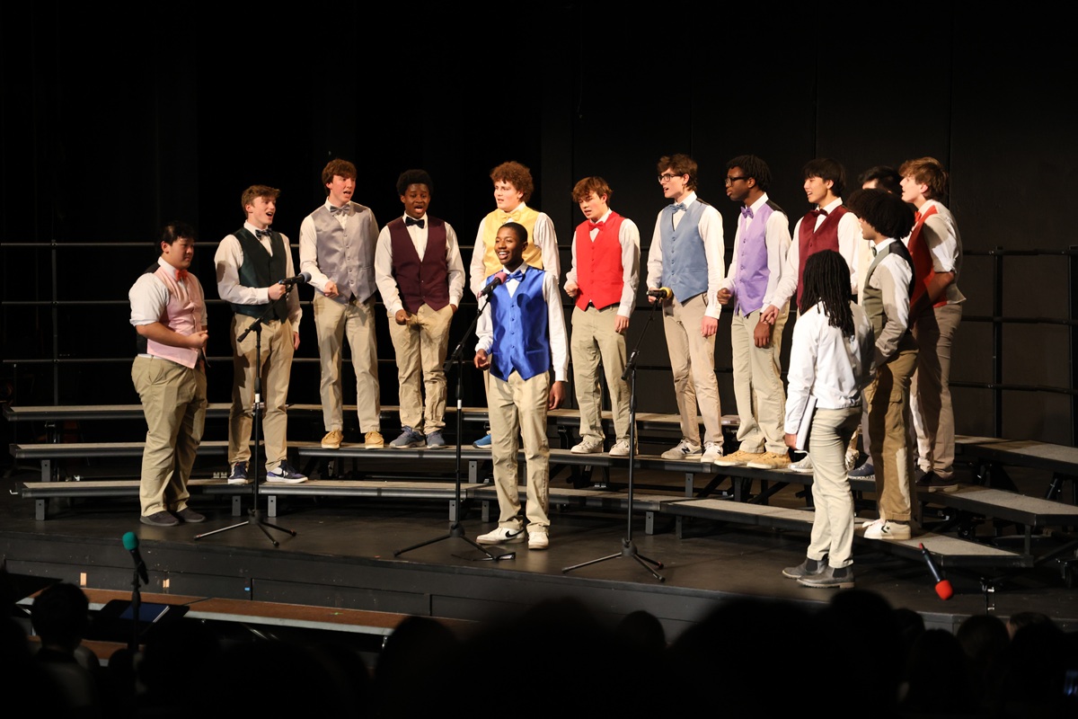 A cappella group in colorful vests performing on stage
