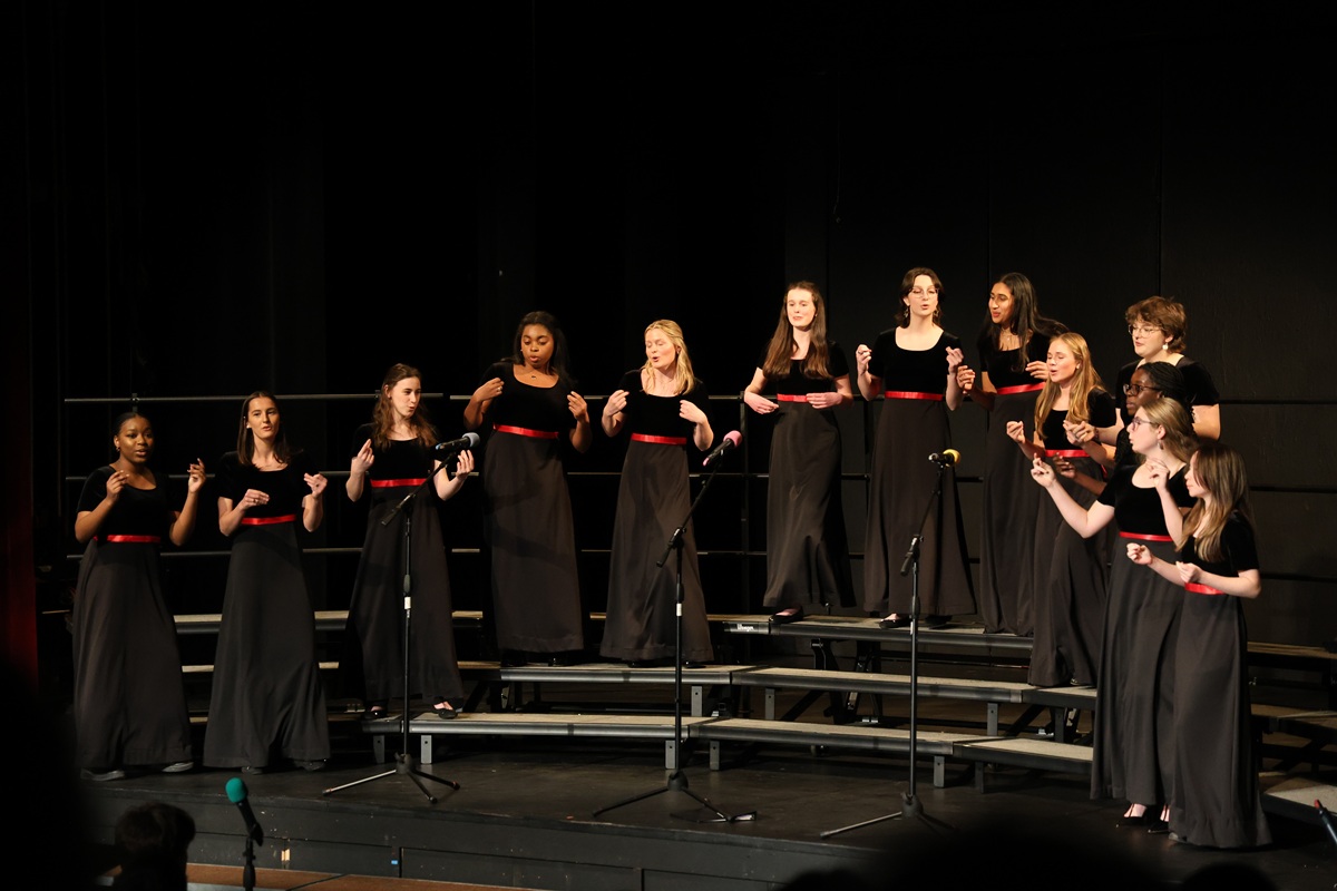 Girls choir in black dresses with expressive gestures