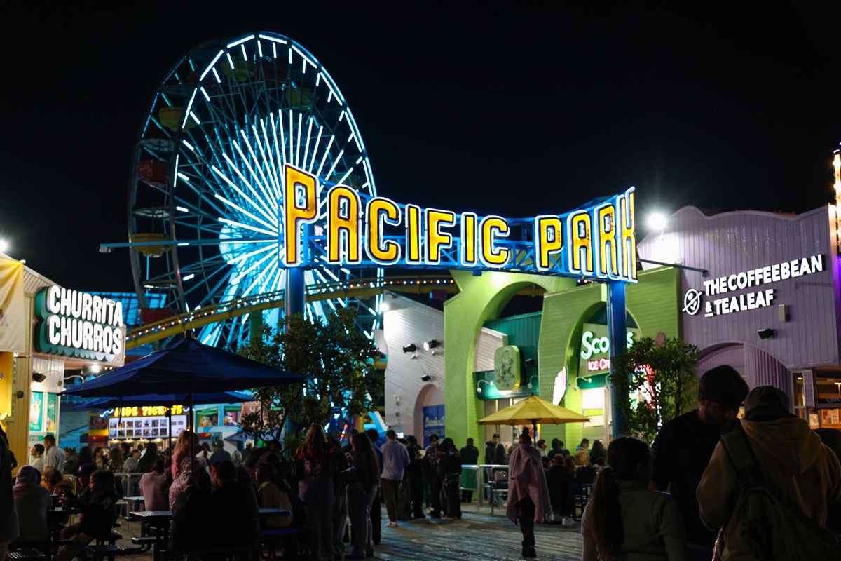 Pacific Park at Santa Monica Pier at night with lit ferris wheel