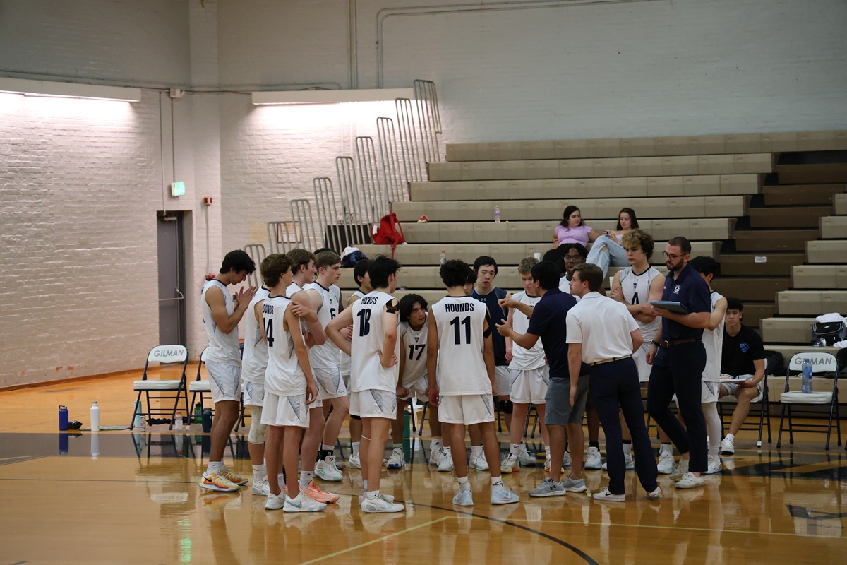 Gilman Hounds volleyball team huddle with coach