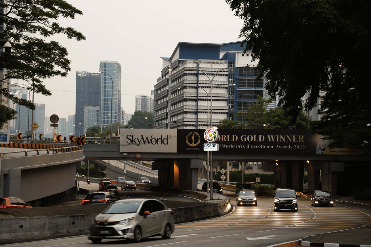 KL highway overpass with SkyWorld banner at dusk
