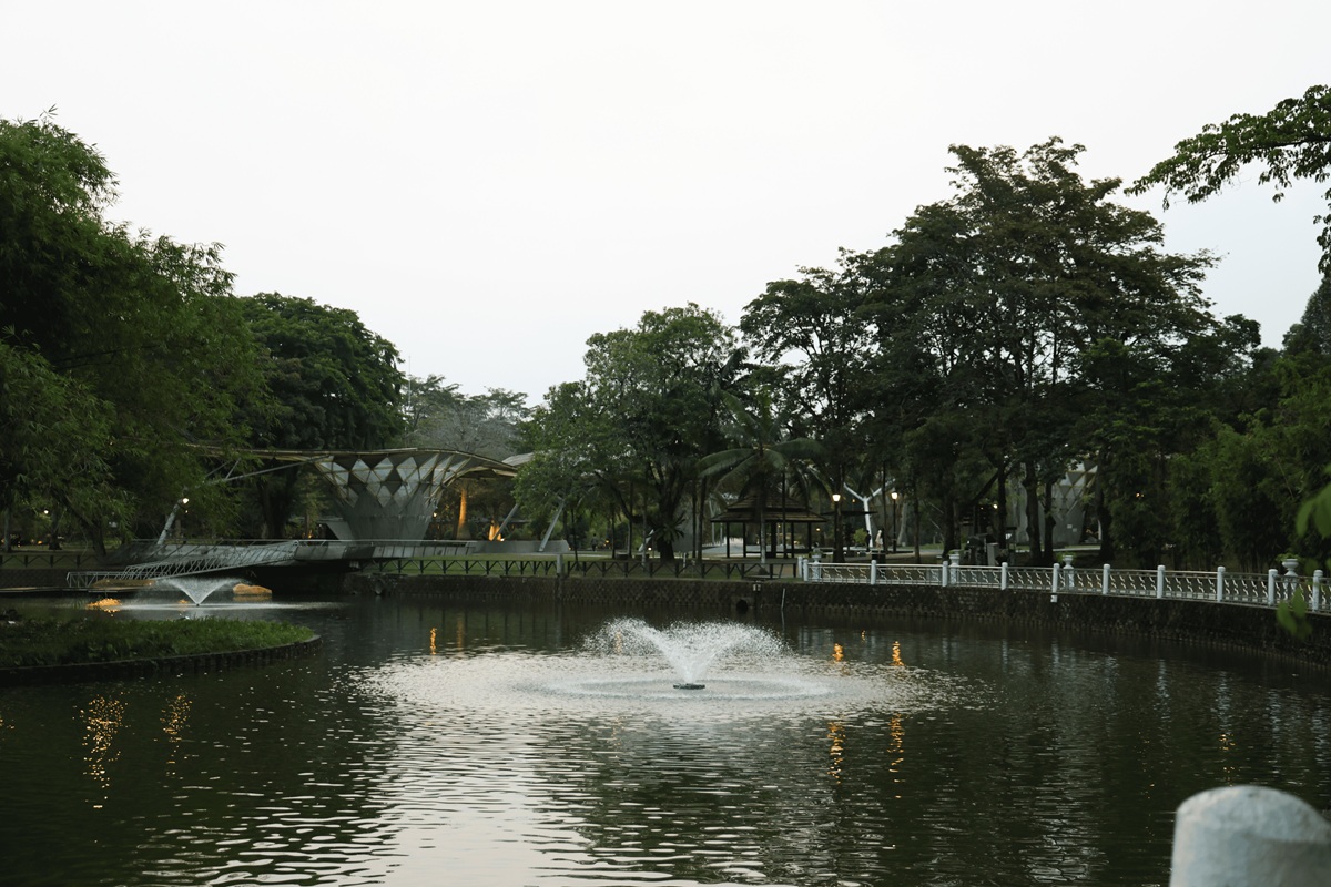 Lake Gardens park pond with pavilion bridge at dusk